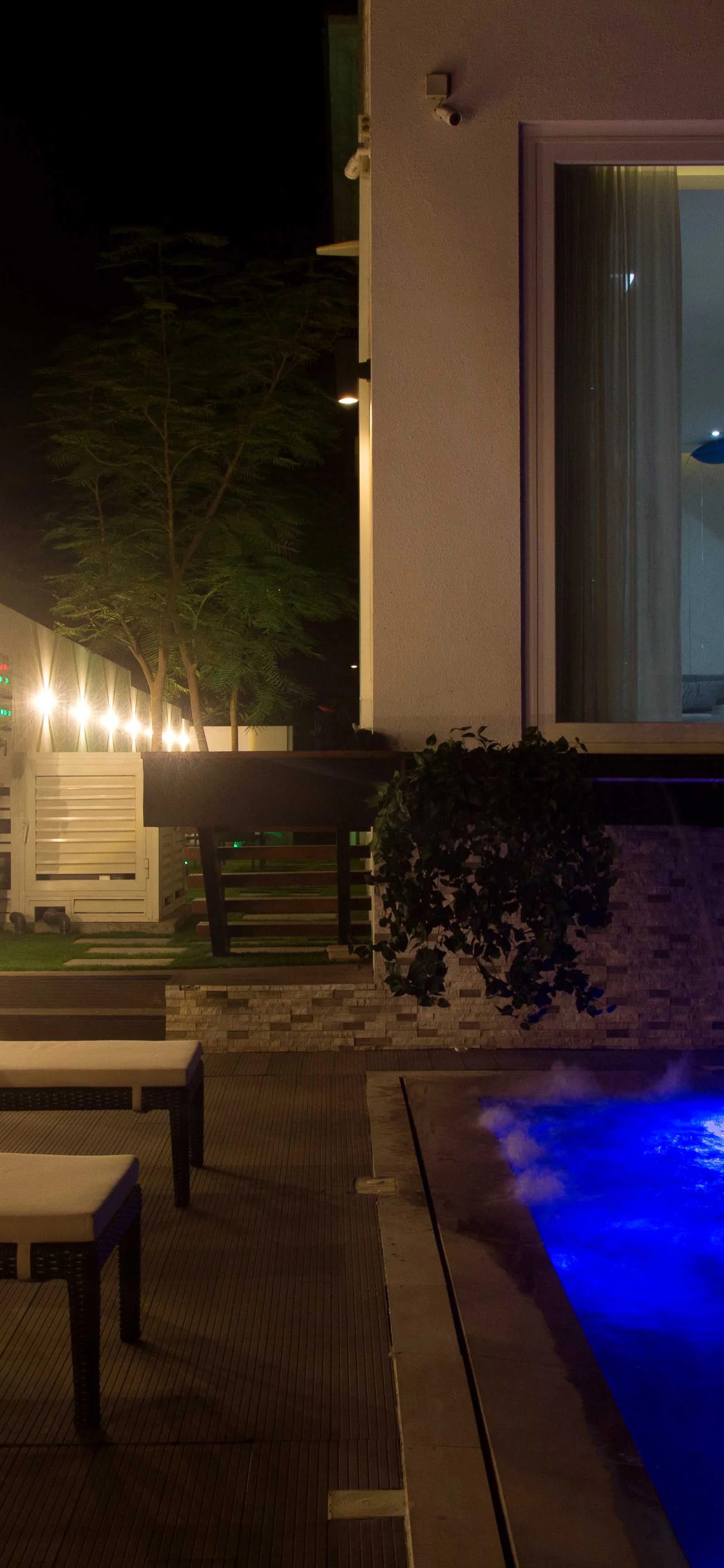 Poolside after dark by Jorge Rangel Interiors, design — industrial
